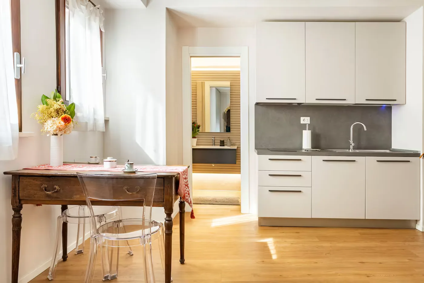 Tavolino con fiori e cucina del loft Fratello Sole
