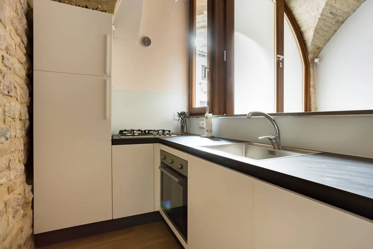 Cucina completa con forno, piano cottura e finestra ad arco